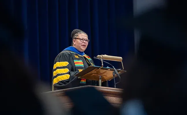 莎拉Willie-LeBreton in academic regalia, speaking at the School for Social Work commencement ceremony.